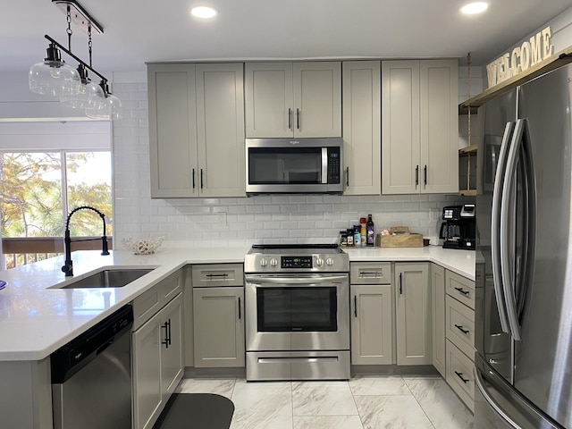 kitchen with gray cabinets, sink, stainless steel appliances, and tasteful backsplash