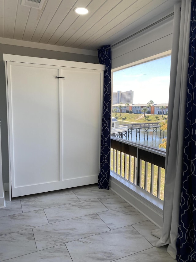 interior space featuring a water view and wooden ceiling