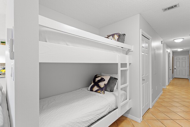 144 Spires Ln Unit 114, Santa Rosa Beach, FL 32459 - bedroom with a textured ceiling and light tile patterned flooring
