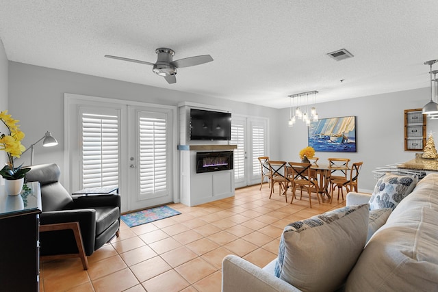 144 Spires Ln Unit 114, Santa Rosa Beach, FL 32459 - tiled living room with french doors, ceiling fan with notable chandelier, and a textured ceiling