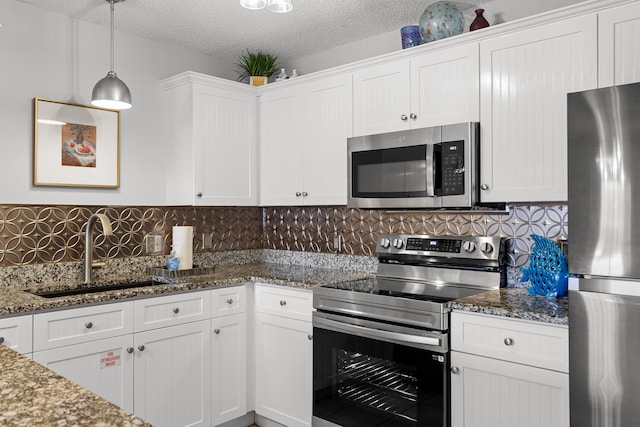 144 Spires Ln Unit 114, Santa Rosa Beach, FL 32459 - kitchen featuring appliances with stainless steel finishes, white cabinets, and dark stone counters