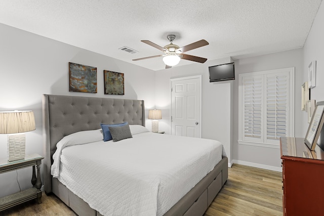 144 Spires Ln Unit 114, Santa Rosa Beach, FL 32459 - bedroom with hardwood / wood-style floors, a textured ceiling, and ceiling fan