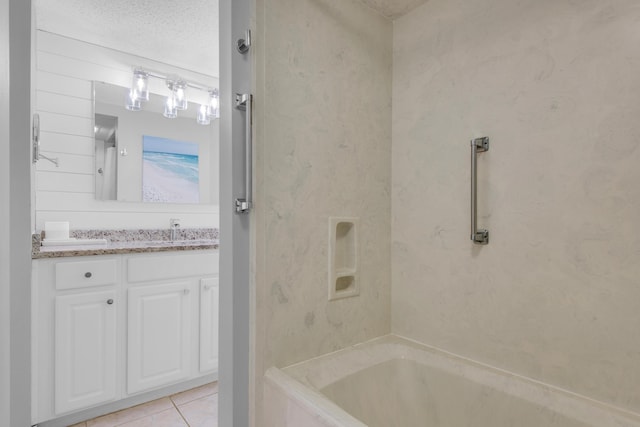 bathroom featuring tiled shower / bath combo, a textured ceiling, tile patterned floors, and vanity