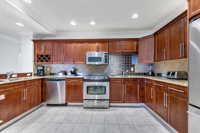 kitchen featuring light stone counters, ornamental molding, and appliances with stainless steel finishes