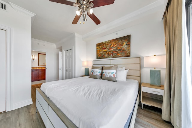 bedroom featuring crown molding, ceiling fan, light hardwood / wood-style flooring, and ensuite bathroom