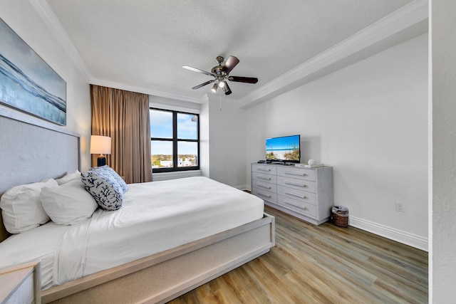 bedroom featuring a textured ceiling, light hardwood / wood-style flooring, ceiling fan, and crown molding