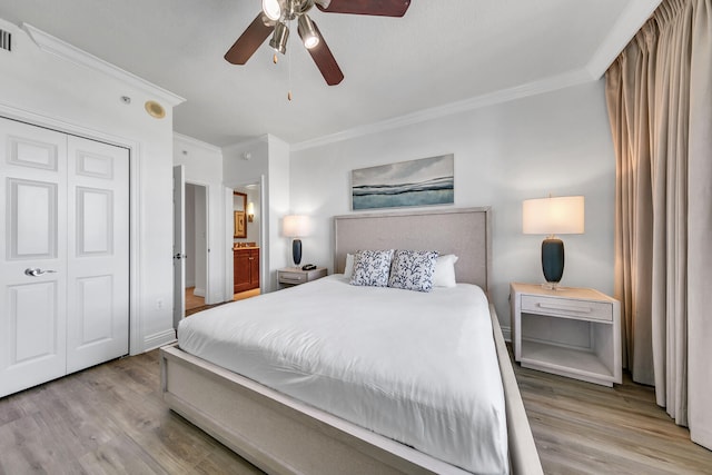 bedroom featuring ceiling fan, a closet, ornamental molding, and light wood-type flooring