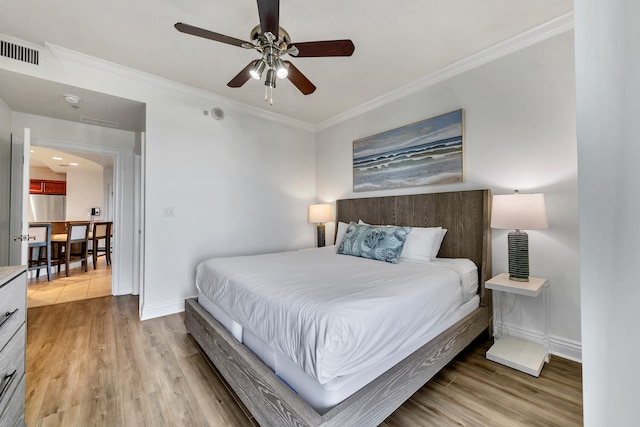 bedroom with hardwood / wood-style flooring, ceiling fan, stainless steel fridge, and ornamental molding