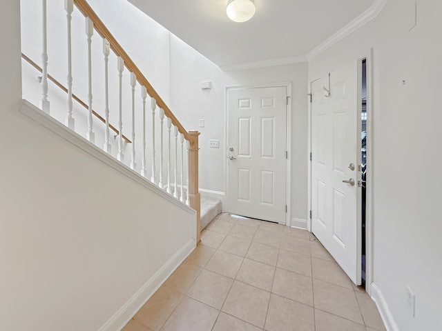 tiled foyer with stairway, crown molding, and baseboards