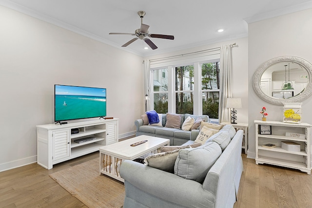 living room featuring light hardwood / wood-style floors, ceiling fan, and crown molding