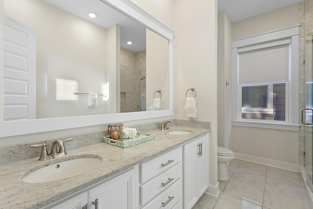 bathroom featuring tile patterned floors, vanity, toilet, and a shower with door