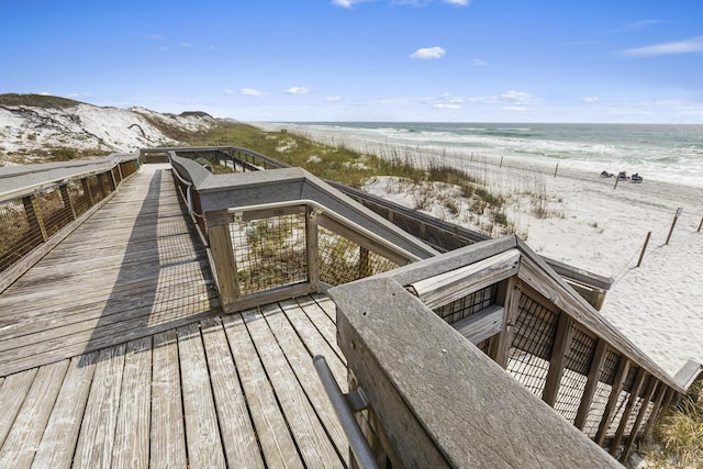 view of property's community with a water view and a view of the beach