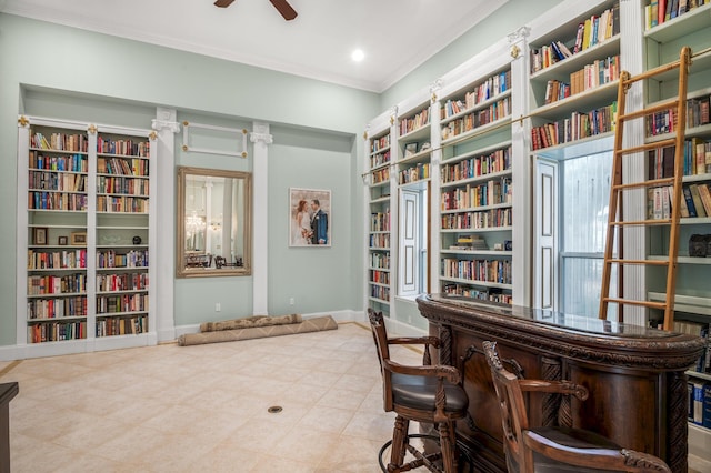 interior space featuring bar, ceiling fan, and crown molding