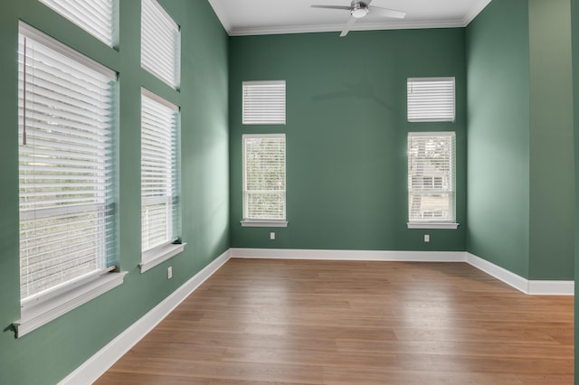 spare room featuring ornamental molding, light hardwood / wood-style flooring, ceiling fan, and a healthy amount of sunlight