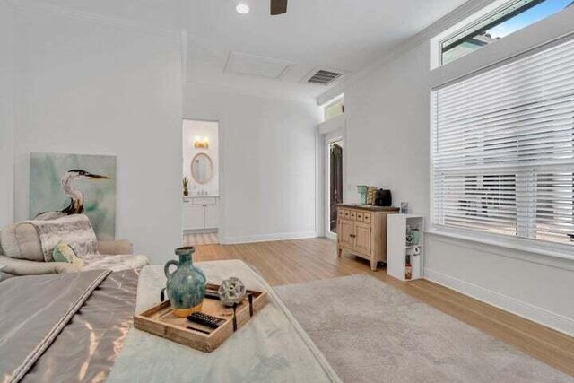 living room with crown molding, light hardwood / wood-style flooring, and ceiling fan