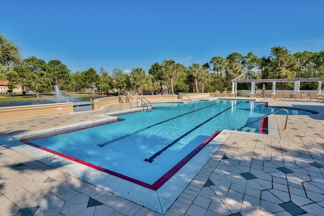 view of pool featuring a water view and a patio