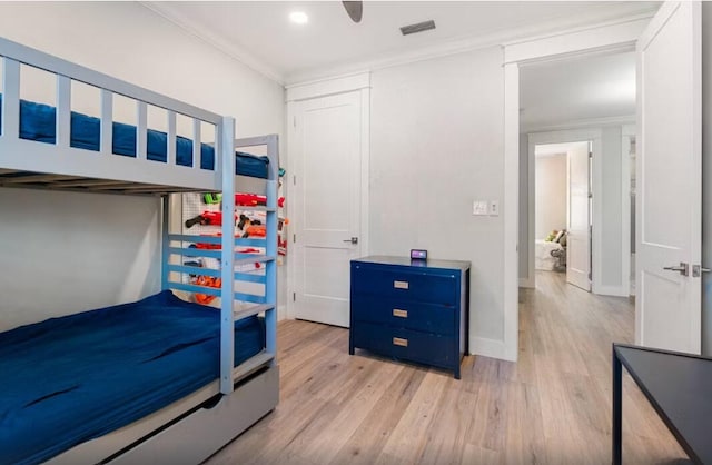 bedroom featuring ceiling fan, light hardwood / wood-style floors, and crown molding