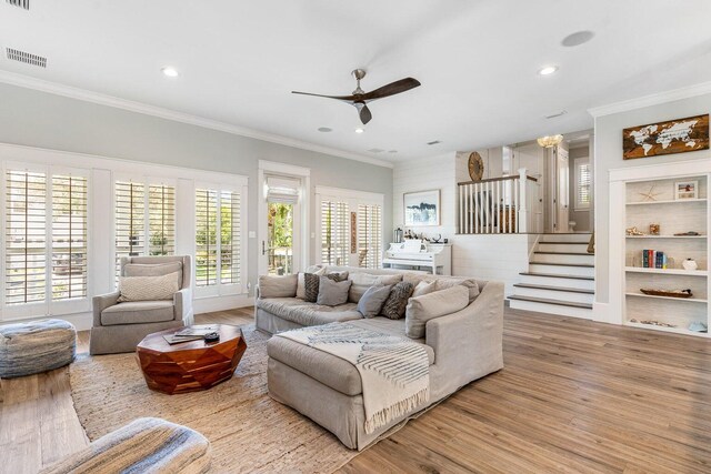 living room with ceiling fan, ornamental molding, and light wood-type flooring