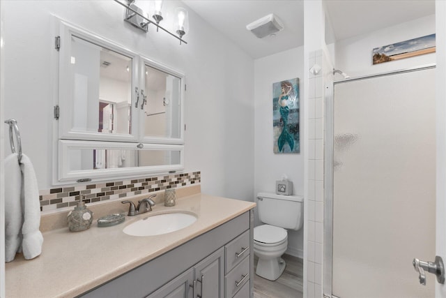 bathroom with hardwood / wood-style flooring, vanity, backsplash, and walk in shower