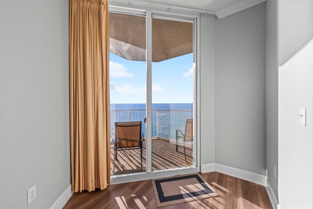 interior space with a water view, dark wood-type flooring, and ornamental molding