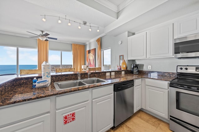 kitchen featuring sink, stainless steel appliances, a water view, white cabinets, and ornamental molding