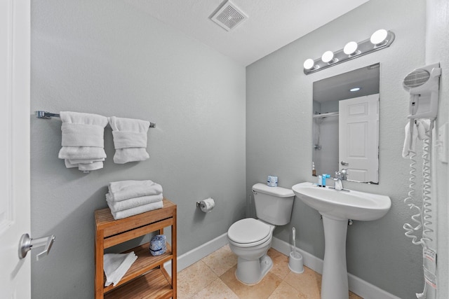 bathroom with tile patterned floors, sink, vaulted ceiling, and toilet