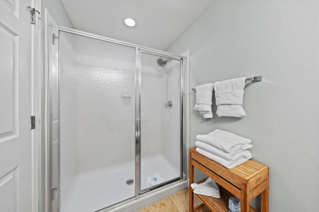 bathroom with tile patterned flooring and a shower with shower door