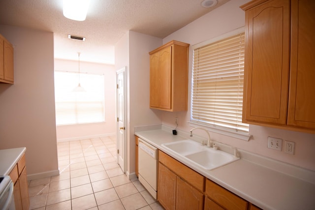 kitchen with a textured ceiling, sink, pendant lighting, light tile patterned floors, and dishwasher