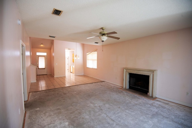 unfurnished living room with a textured ceiling, ceiling fan, and light tile patterned flooring