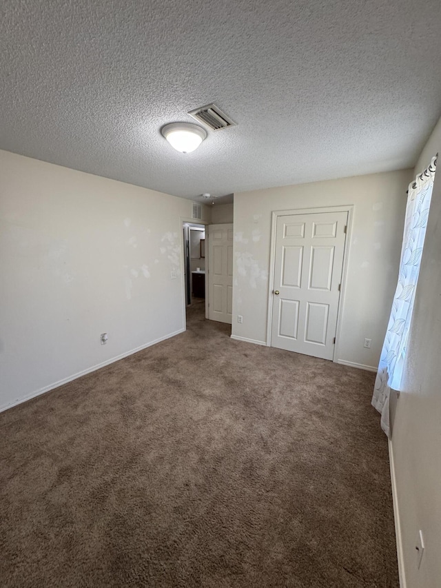 unfurnished bedroom featuring dark colored carpet and a textured ceiling