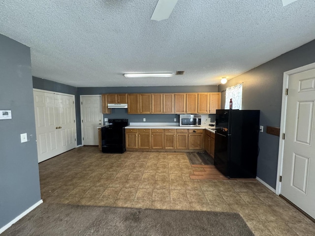 kitchen with a textured ceiling and black appliances