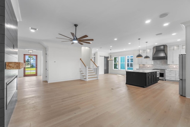 kitchen featuring decorative backsplash, appliances with stainless steel finishes, custom exhaust hood, white cabinets, and a center island