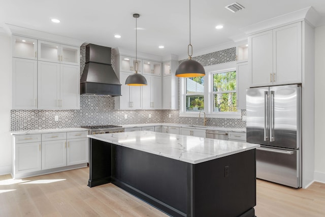 kitchen with custom exhaust hood, a center island, white cabinetry, and stainless steel appliances