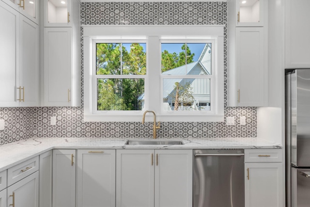 kitchen with white cabinets, light stone countertops, sink, and appliances with stainless steel finishes