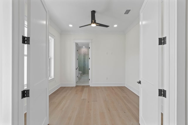 spare room with a wealth of natural light, light wood-type flooring, ceiling fan, and ornamental molding