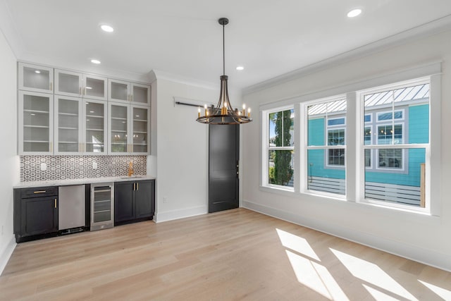 interior space featuring pendant lighting, an inviting chandelier, fridge, light hardwood / wood-style floors, and beverage cooler