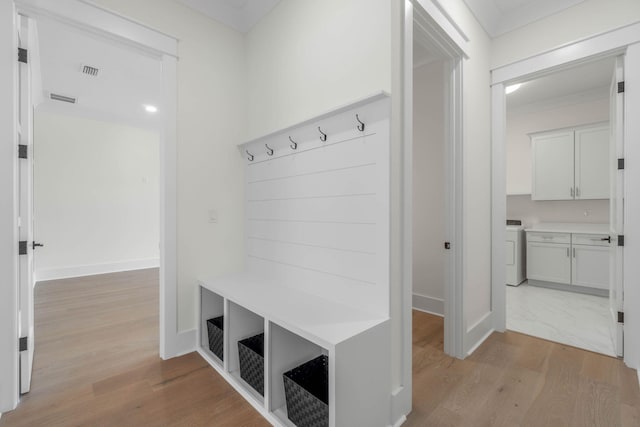 mudroom featuring washer / clothes dryer, crown molding, and light hardwood / wood-style floors