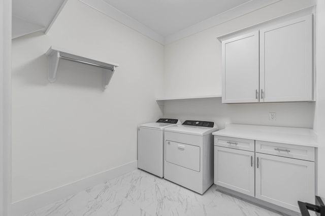 washroom featuring washer and dryer, crown molding, and cabinets