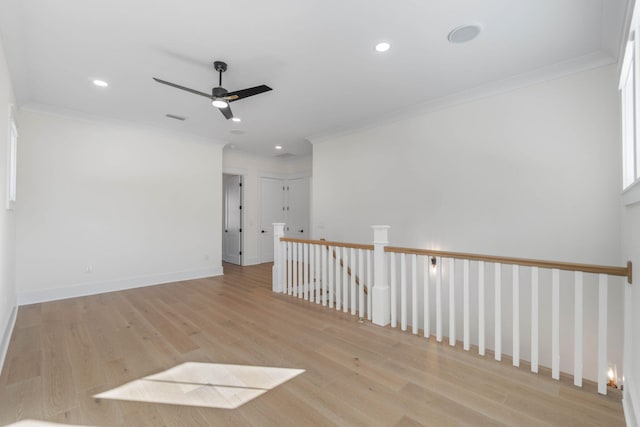 unfurnished room with ceiling fan, light wood-type flooring, and ornamental molding