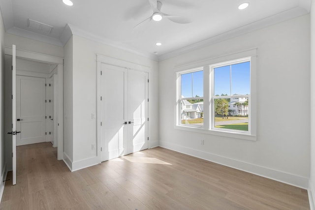 unfurnished bedroom featuring light wood-type flooring, a closet, ceiling fan, and crown molding