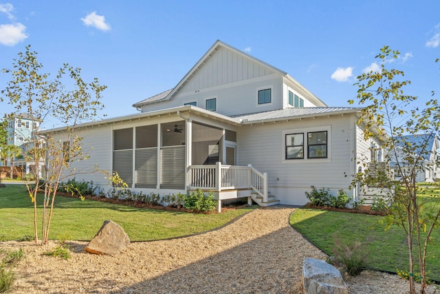 back of house with a lawn and a sunroom