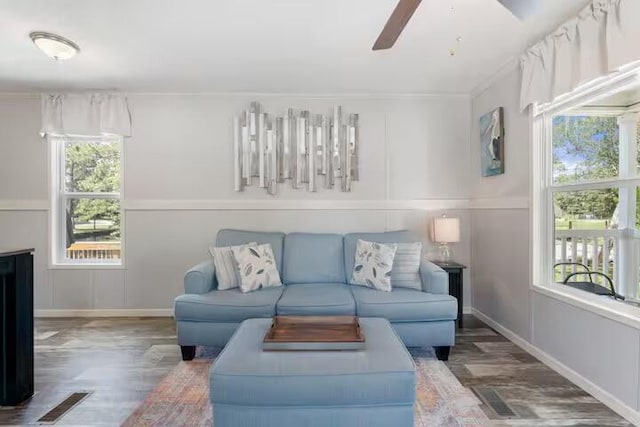 living room featuring ceiling fan, dark hardwood / wood-style floors, and crown molding