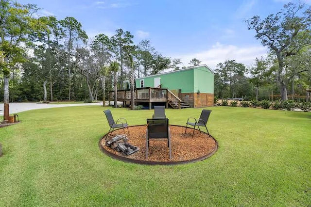 view of yard featuring a deck and an outdoor fire pit