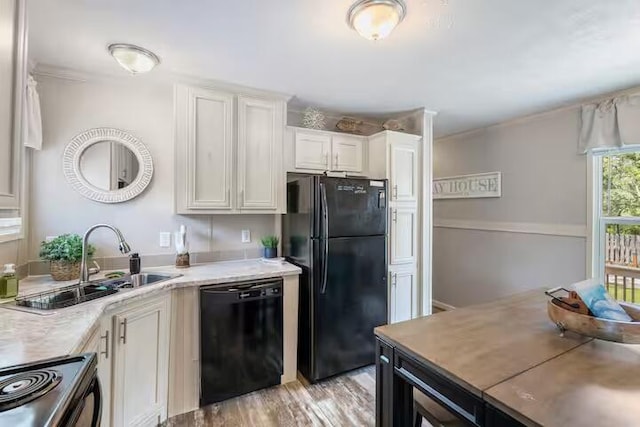 kitchen with sink, white cabinets, black appliances, and light hardwood / wood-style floors