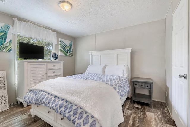 bedroom with a textured ceiling and dark hardwood / wood-style floors