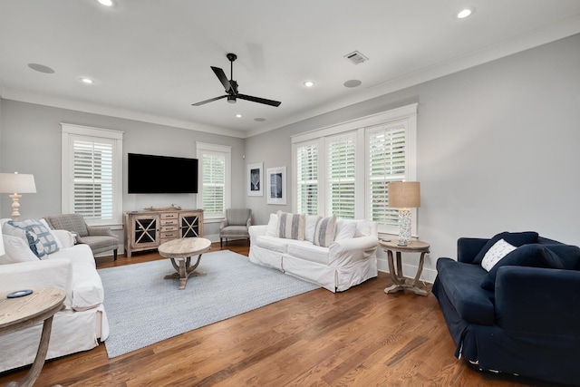 living room with hardwood / wood-style flooring, ceiling fan, and crown molding