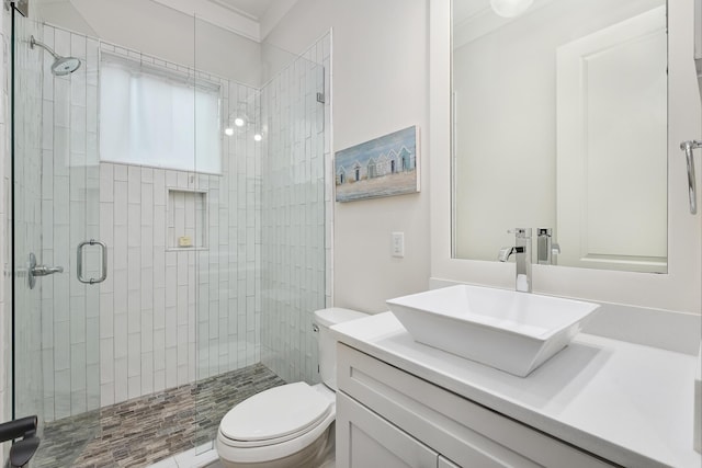 bathroom featuring vanity, toilet, ornamental molding, and walk in shower