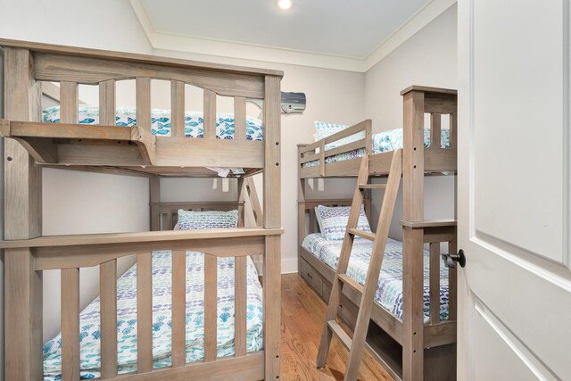 bedroom with light wood-type flooring and crown molding