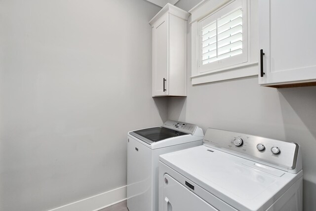 washroom with cabinets and washer and clothes dryer