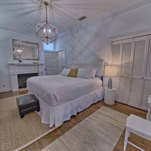 bedroom featuring crown molding, a closet, a chandelier, and hardwood / wood-style flooring